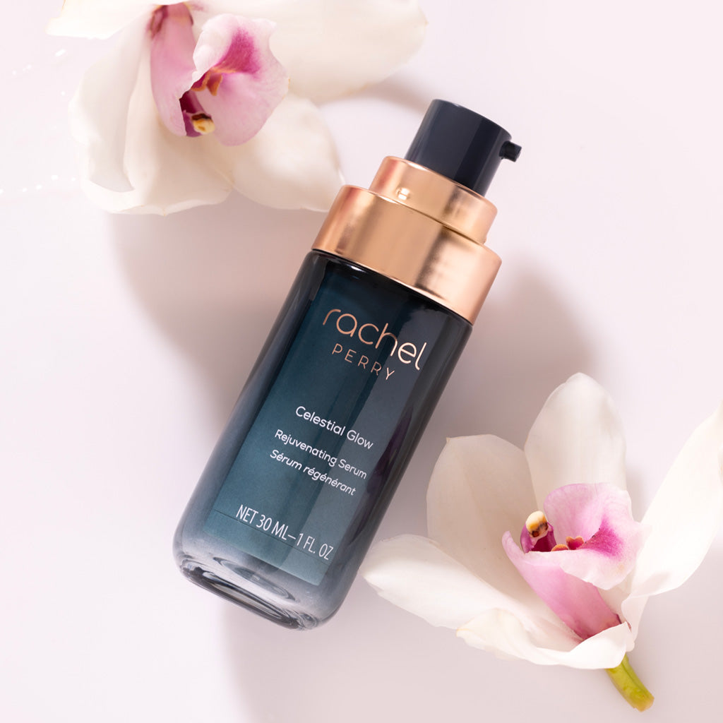 celestial glow rejuvenating serum bottle with rachel perry branding on a light background with flowers