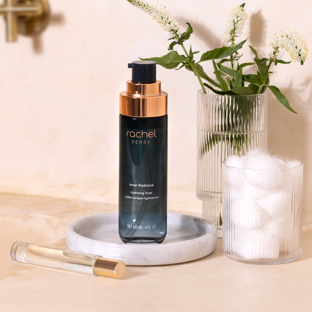 rachel perry skincare inner radiance hydrating toner bottle on a marble tray with flowers