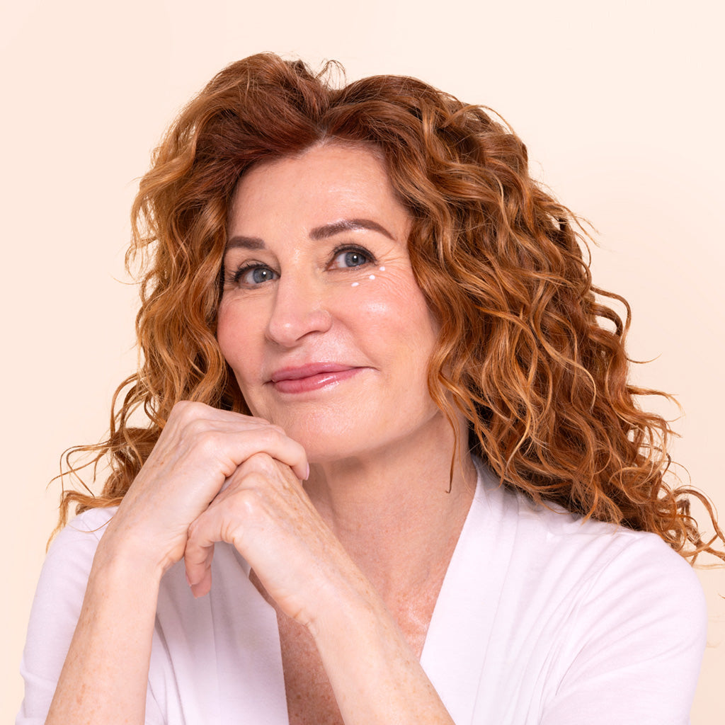 woman with red curly hair applying rachel perry daily eye treatment clean natural skincare