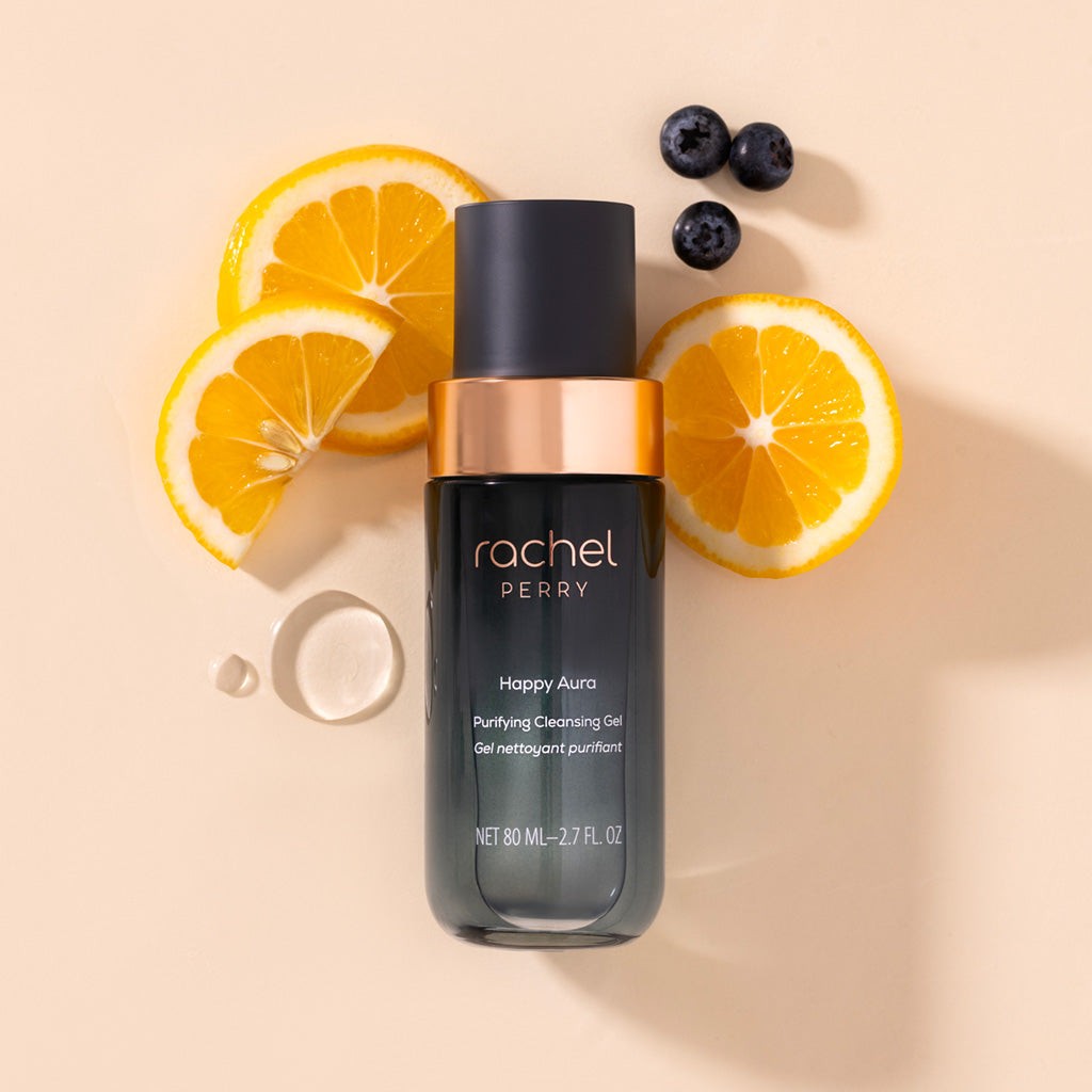 happy aura purifying cleansing gel bottle by rachel perry natural clean Skincare with lemon slices and blueberries on a beige background